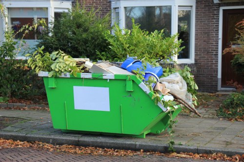 Contractor vehicle being loaded with secured waste containers under supervision