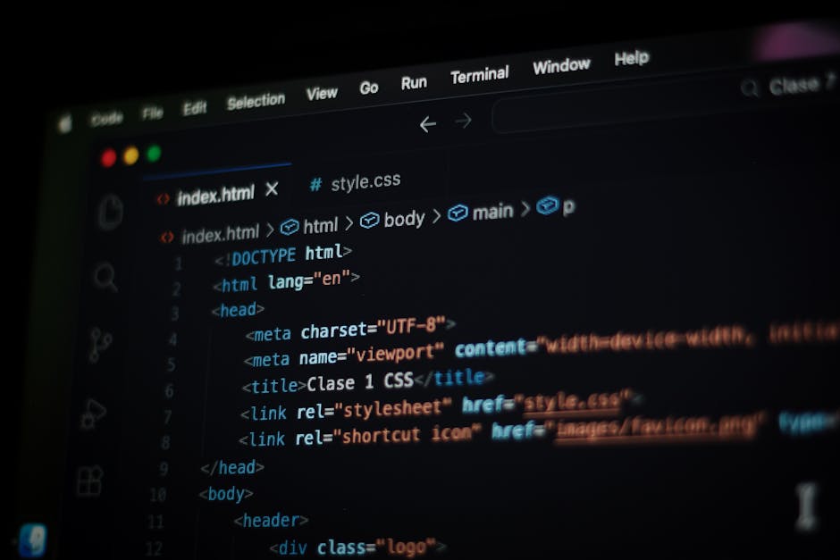 A black laptop computer with a glowing red keyboard and blurred screen displaying lines of code or programming text, situated on a dark surface. Next to the laptop, on the right side of the image, is